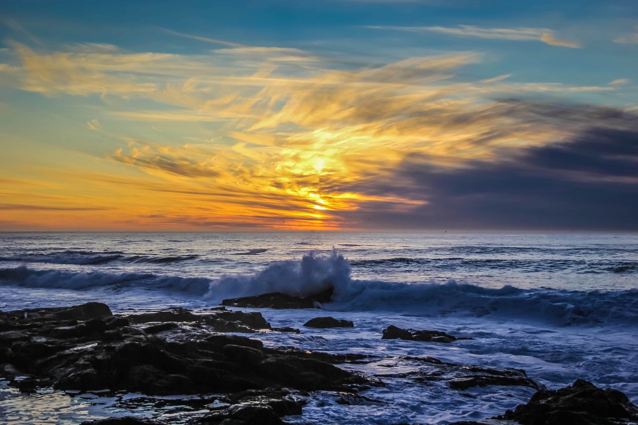 Image of a wave breaking on rocks on the shore